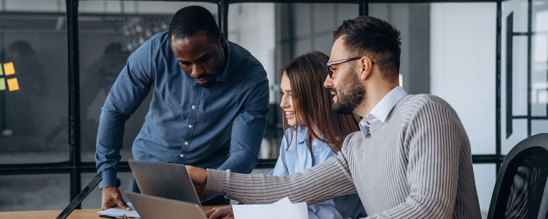Drei Personen arbeiten an Laptops