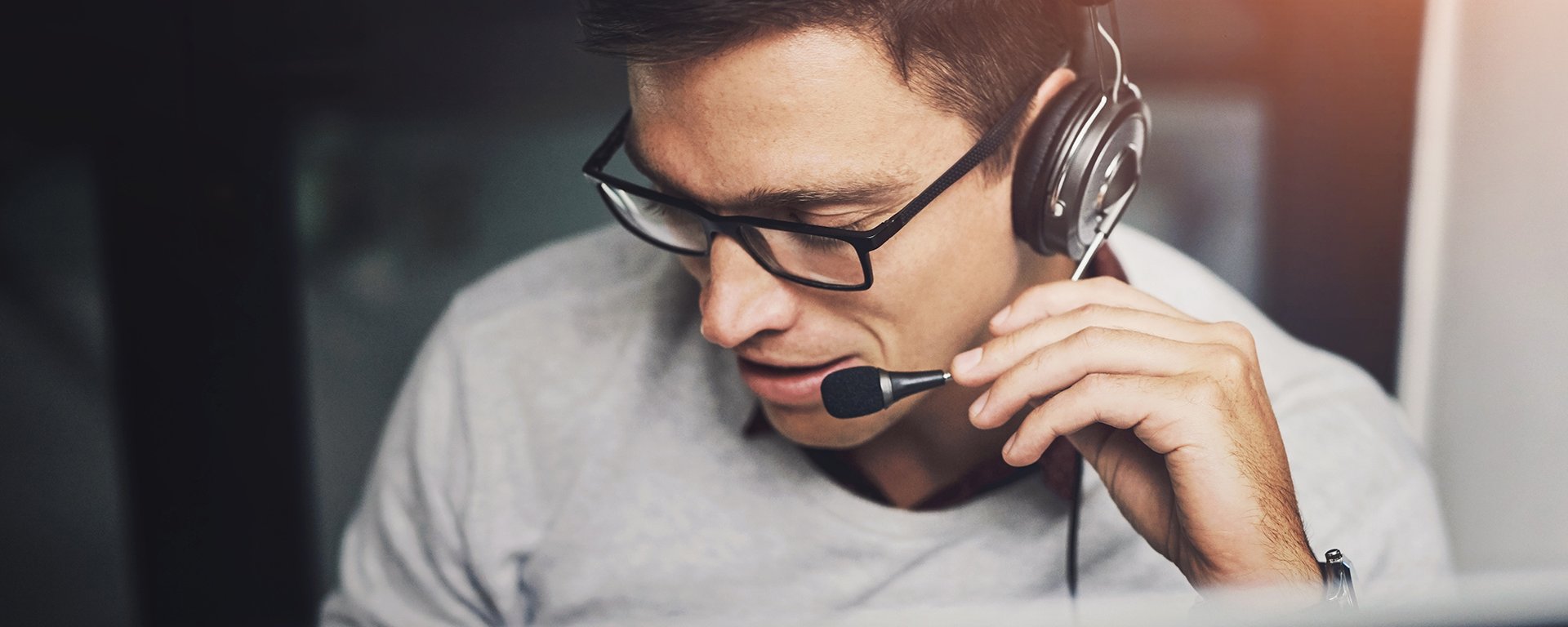 Ein Mann mit Brille und Headset führt ein Telefongespräch