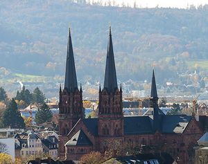 Die Kirche Sankt Johann, Johanneskirche, in Freiburg überragt die Dächer der Gebäude im Umfeld. Bäume sind herbstlich gefärbt. Die Kirche Sankt Johann, Johanneskirche, in Freiburg überragt die Dächer der Gebäude im Umfeld. Bäume sind herbstlich gefärbt.